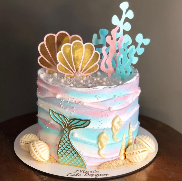 Bolo de aniversário com sereias em um fundo roxo